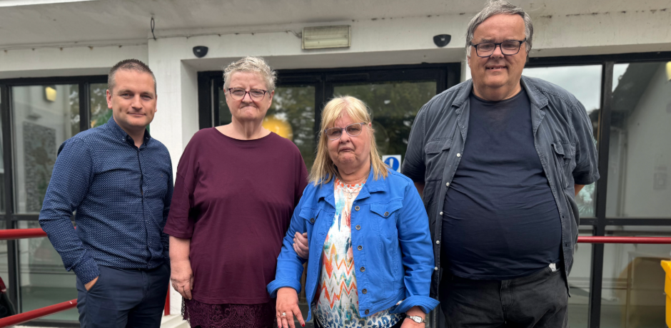 Four people standing outside a building.