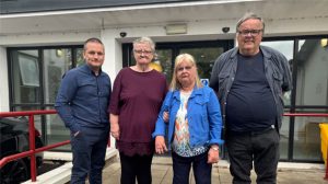 4 people standing in front of a building