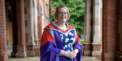 A woman wearing a graduation gown at Queen's University.
