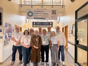 A group of volunteers stand in the hospital foyer with the Mayor of Causeway Coast and Glens Borough Council.