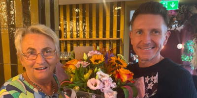 A woman receives a large bouquet of flowers from a man.