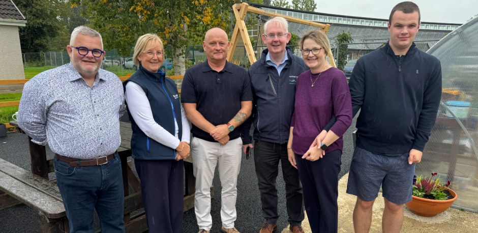 A group of people standing together in a playground garden.