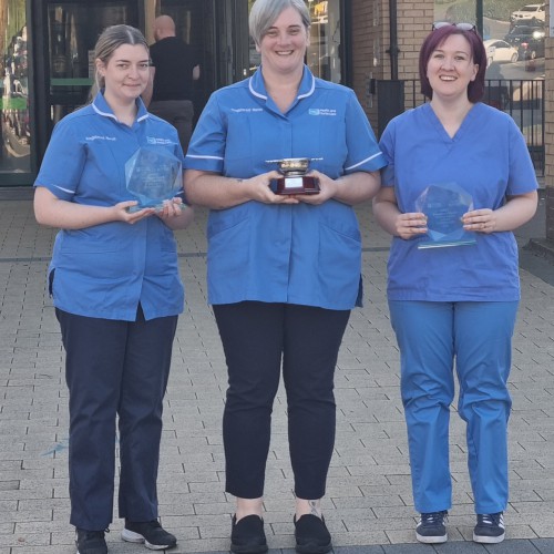 Aiobhin McElroy, Shelley Taylor and Gemma Harper pictured with their Northern Ireland Practice and Education Council (NIPEC) for Nursing and Midwifery awards at Antrim Area Hospital where all three of them now work after completing their Nursing degrees through the Open University. Three nurses in uniform standing outside Antrim Hospital holding awards.